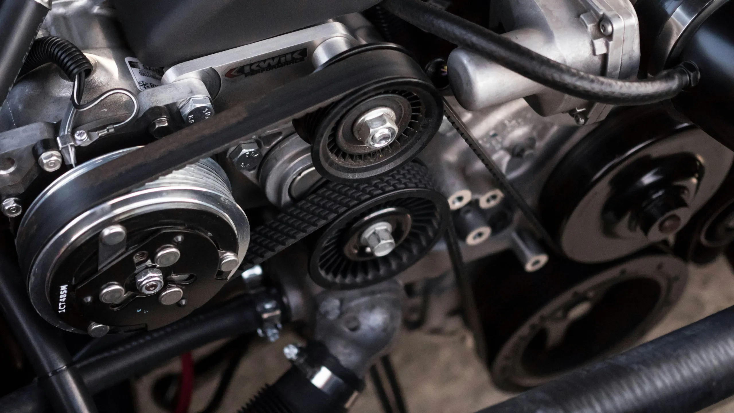 Primer plano de la correa de transmisión y las poleas en un motor de coche